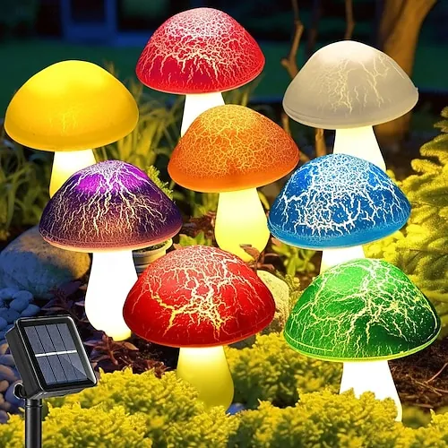 Colorful solar mushroom lights glowing in a garden bed at night